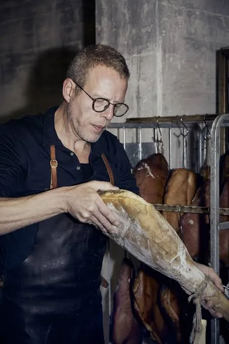 Michael Museth med en lufttørret skinke i modningsrummet